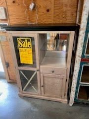 A cabinet with a sale sign on it is sitting in a room.
