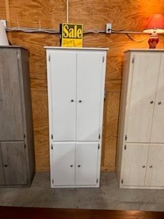 A white cabinet with a sale sign on top of it.