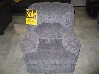 A gray recliner with a yellow sale sign on it.