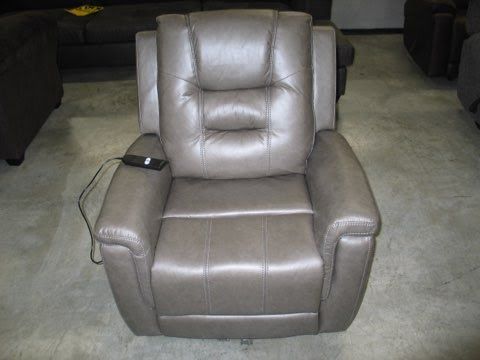 A grey leather recliner is sitting on a carpet in a living room.