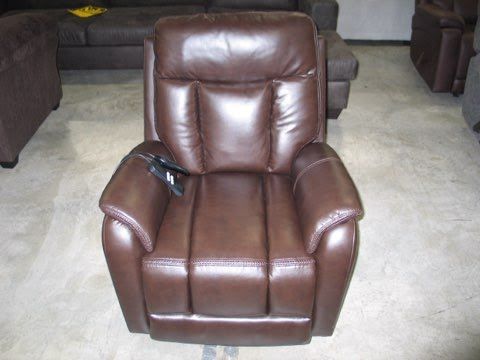 A brown leather recliner is sitting in a living room next to a couch.