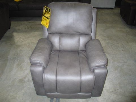 A grey leather recliner with a sale sign on it