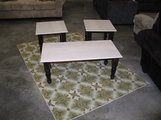 Three coffee tables are sitting on a rug in a living room.