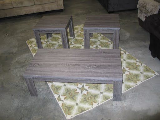 A set of three coffee tables sitting on top of a rug.