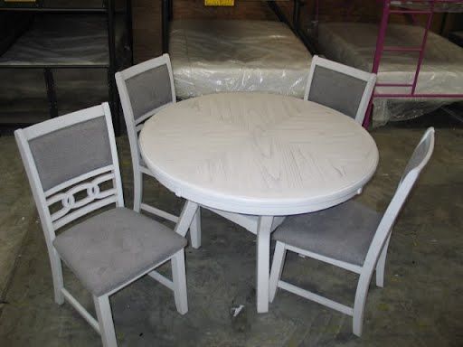 A round table with four chairs in a warehouse