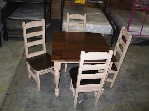 A wooden table and chairs in a room with bunk beds