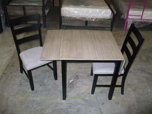 A table and two chairs are sitting on a concrete floor.