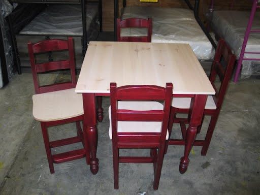 A wooden table and chairs in a room with bunk beds