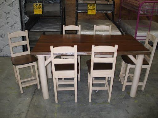 A wooden table and chairs in front of a sign that says sale