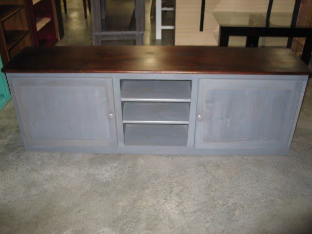 A gray cabinet with a wooden top sits on a concrete floor