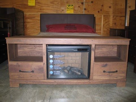 A wooden entertainment center with a fireplace underneath it