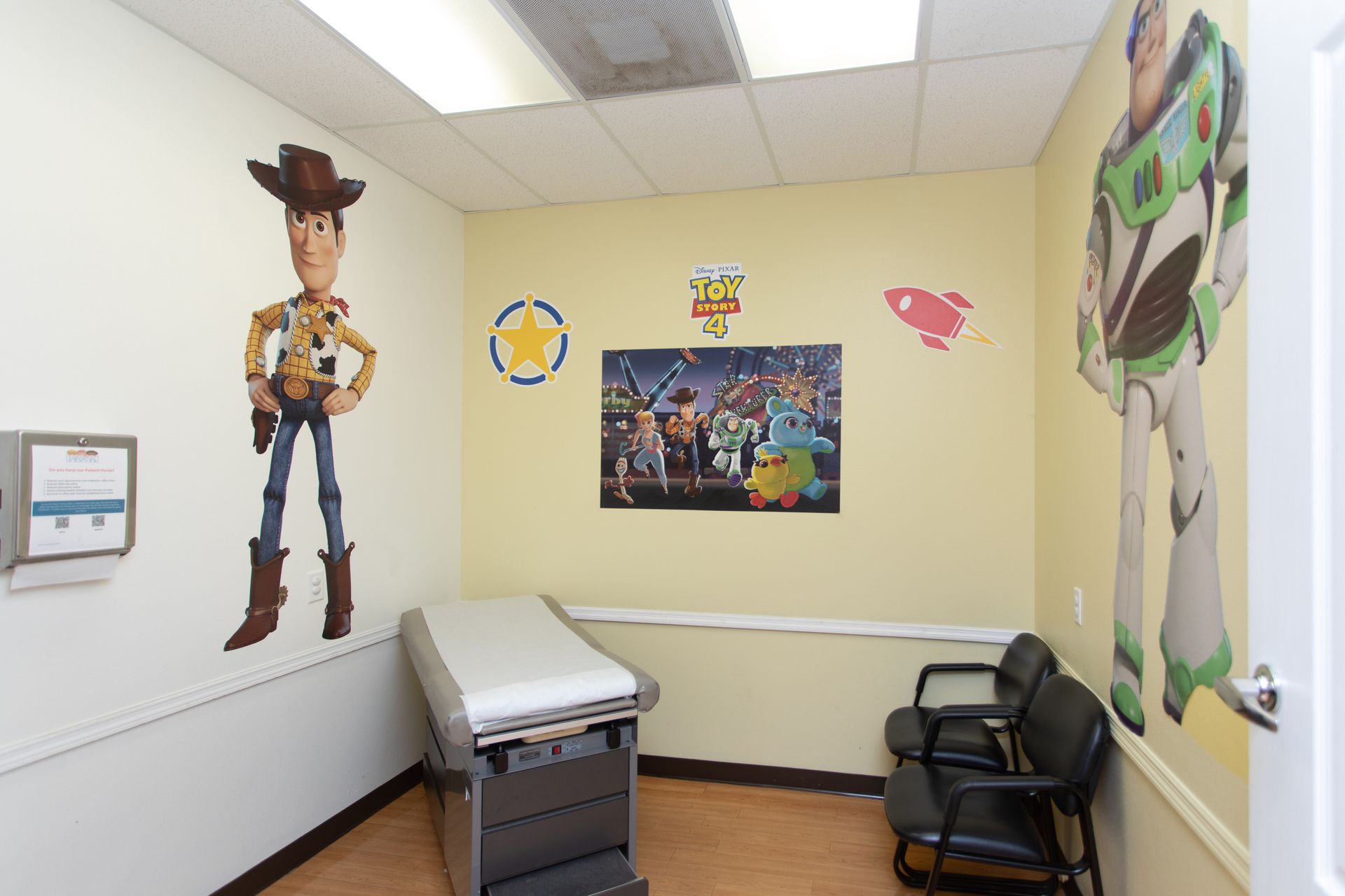 A doctor 's office with a woody and buzz lightyear mural on the wall.