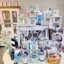 Shop display with mugs, candles, and decorations.