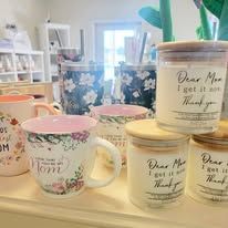 Mugs and jars of candles on a shelf, floral patterns, bright.