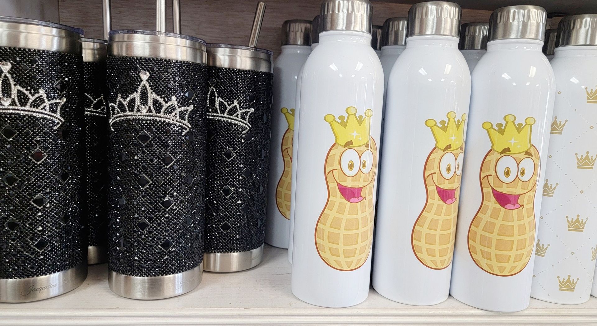 Water bottles: black bejeweled with crowns, white with cartoon peanuts wearing crowns.