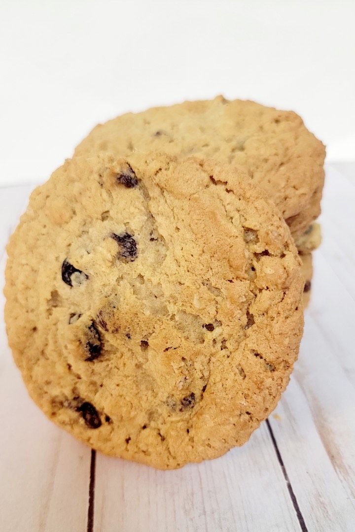 Chocolate chip cookies stacked on a white wooden surface.