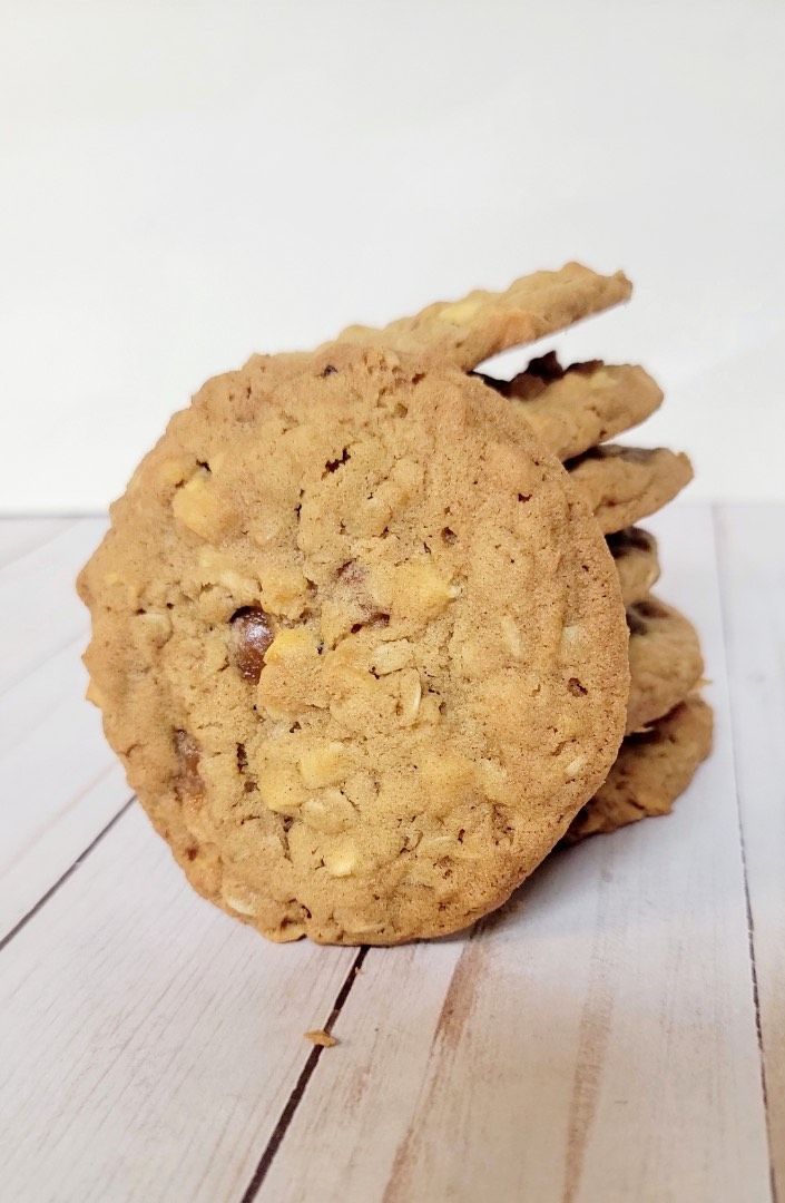 Stack of golden brown cookies on a light wood surface.