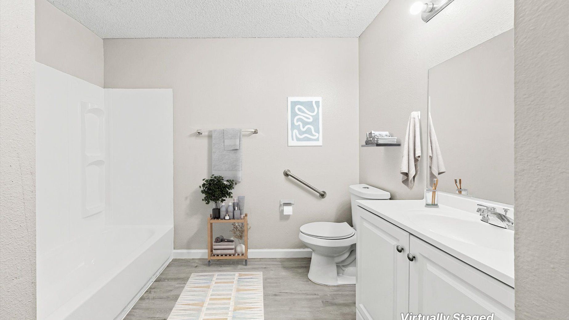 Modern apartment bathroom with bathtub/shower, toilet, and vanity.