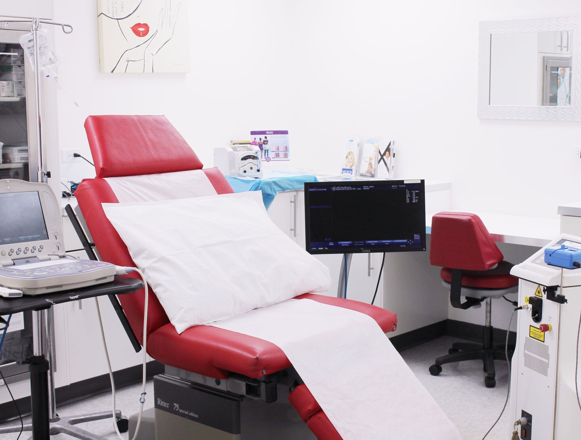 A hospital room with a red chair and a monitor