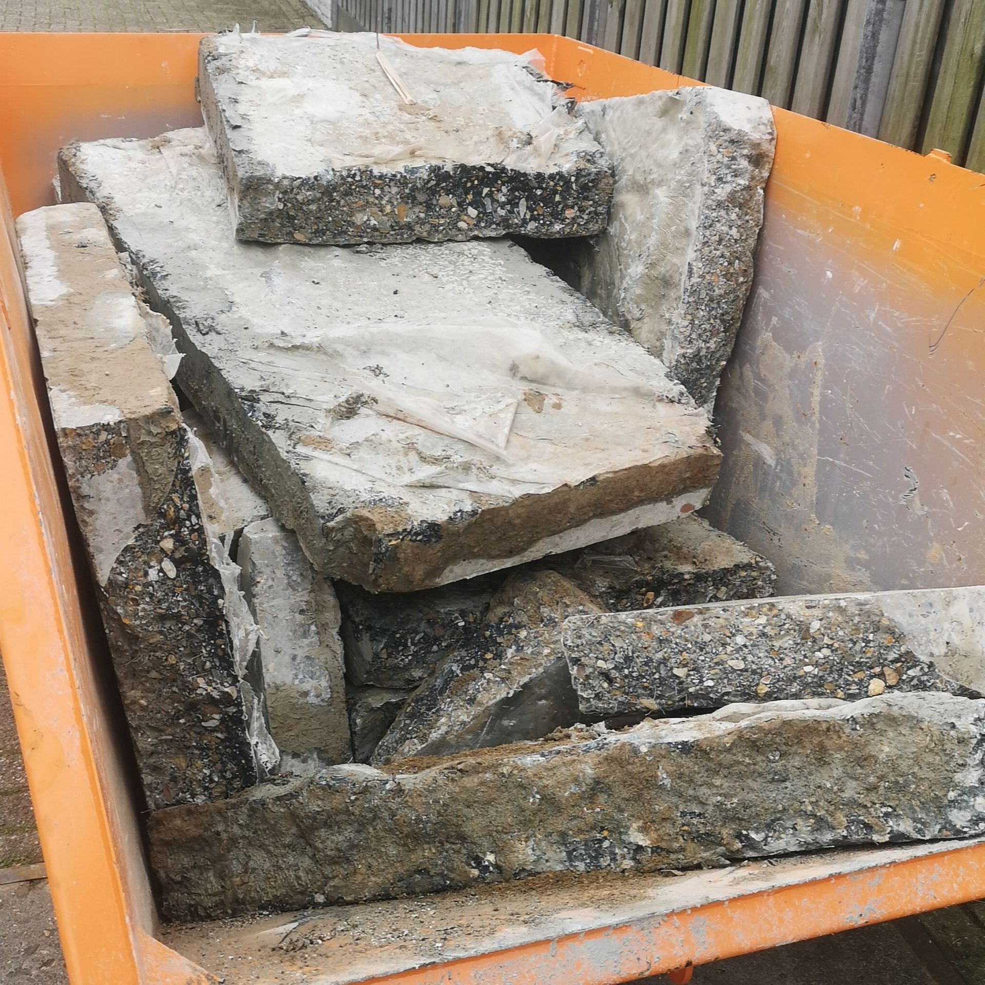 A wheelbarrow filled with a pile of concrete blocks