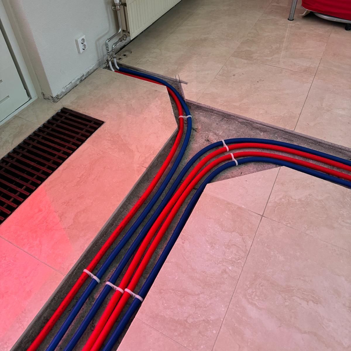 Cut A bunch of red and blue pipes on the floor with a concrete saw