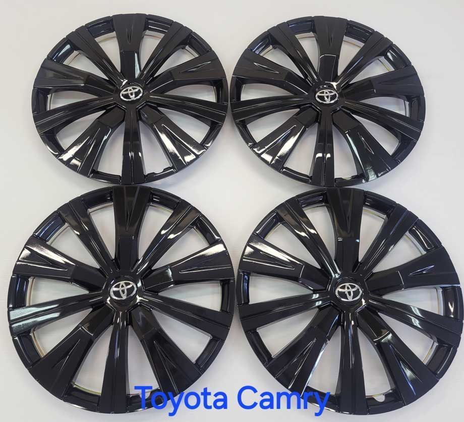 Four black Toyota Camry hubcaps.