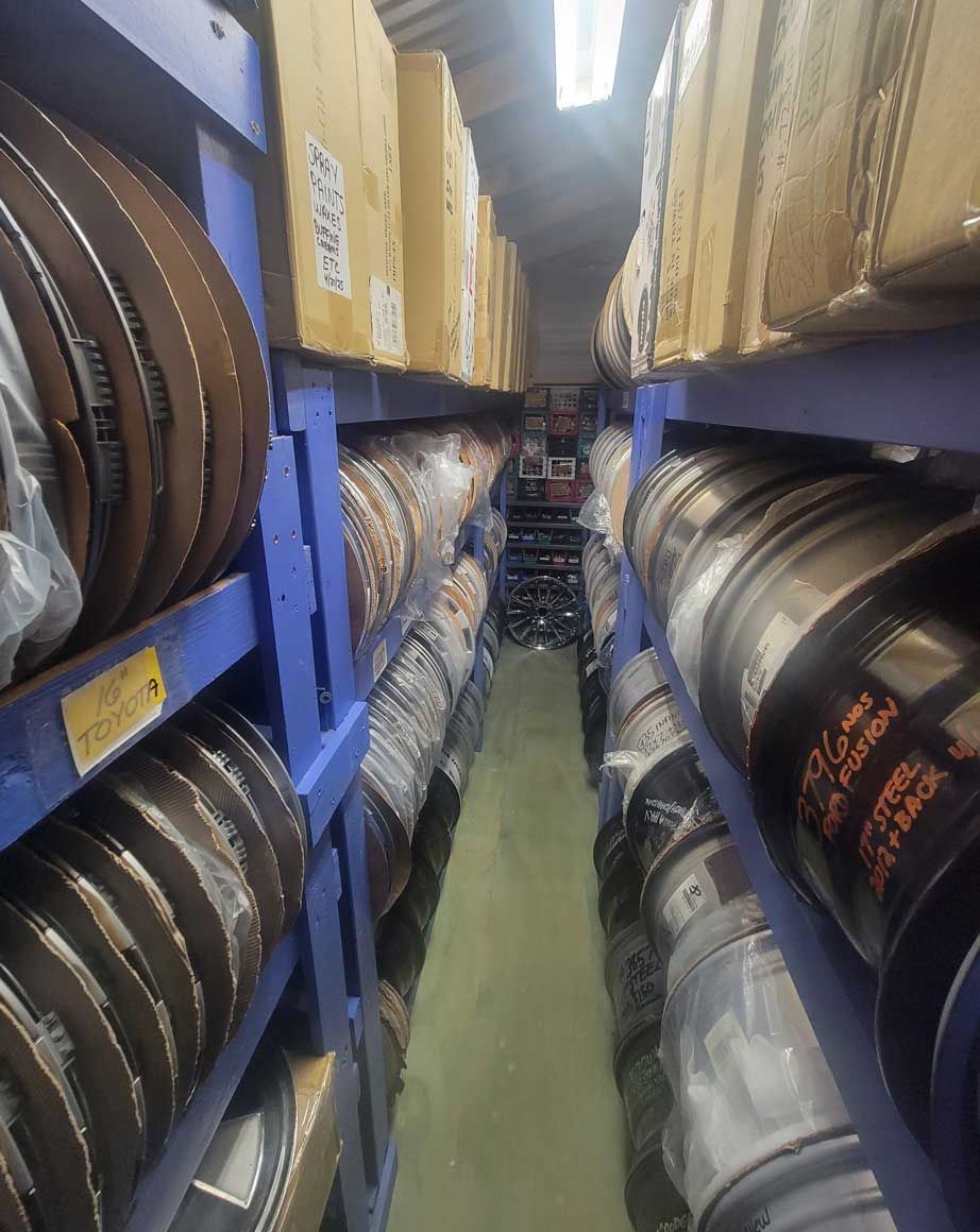 Shelves stacked with spools and boxes in a warehouse aisle. Shelves stacked with spools and boxes in a warehouse aisle.