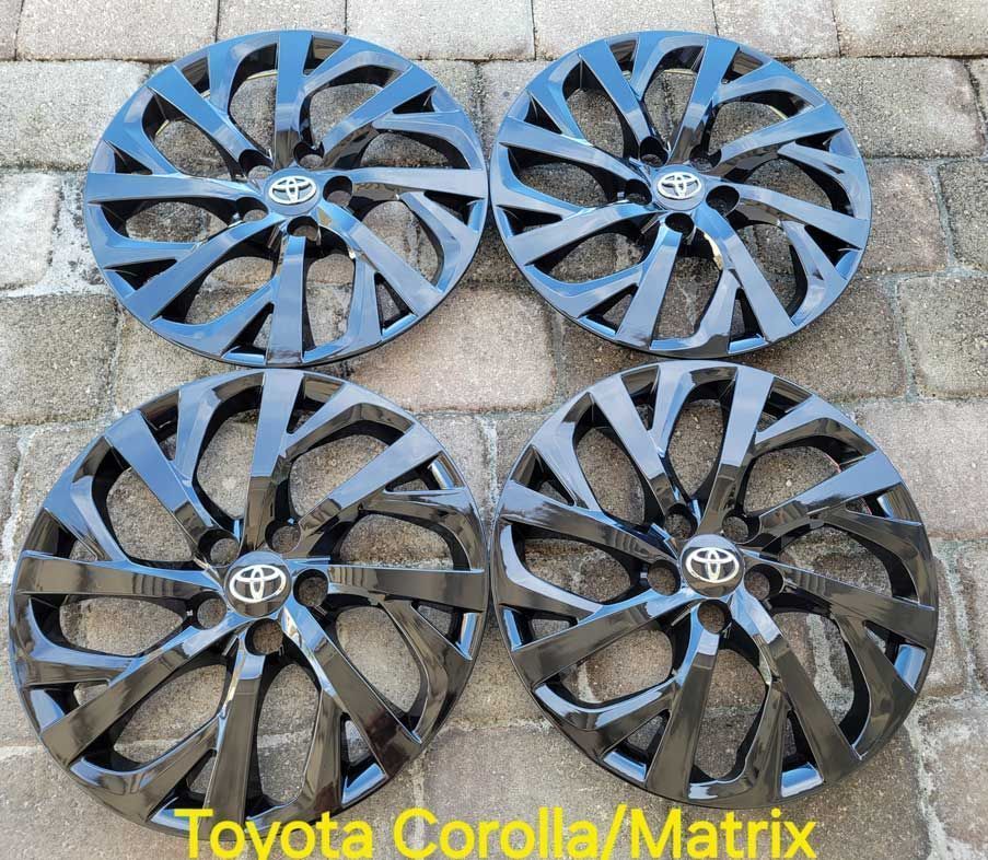 Four black Toyota Corolla/Matrix hubcaps.