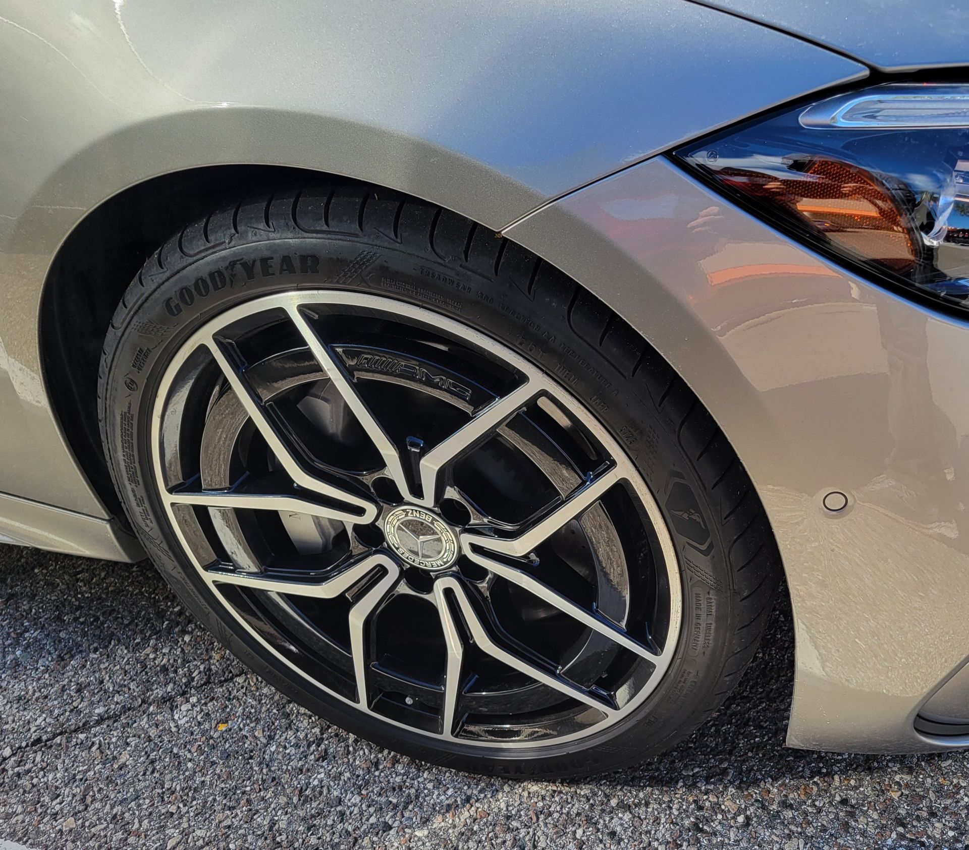 Car rims on a shelf, with black and silver rims in the foreground and a tan rim to the right. Car rims on a shelf, with black and silver rims in the foreground and a tan rim to the right.
