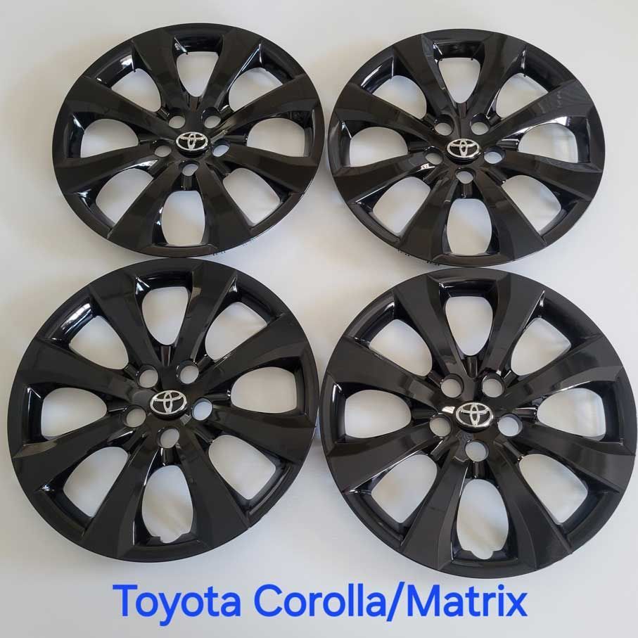 Four black Toyota Corolla/Matrix wheel covers.