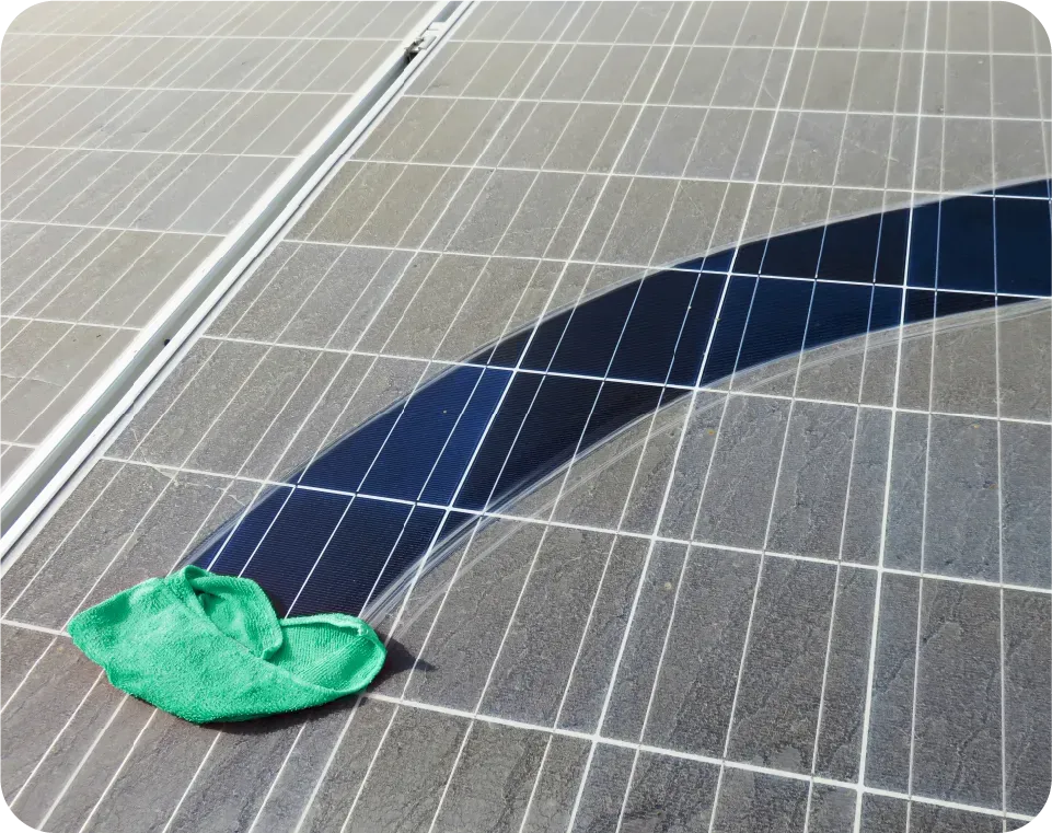 A green cloth is being used to clean a solar panel