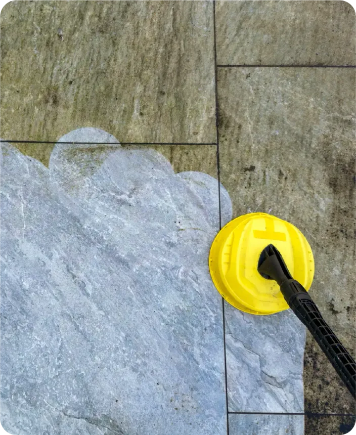 A yellow cleaning tool is being used to clean a tile floor.