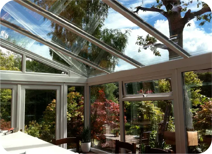 A conservatory with a glass roof and lots of windows