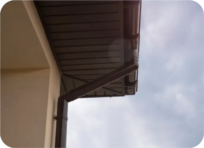 A brown gutter on the side of a building