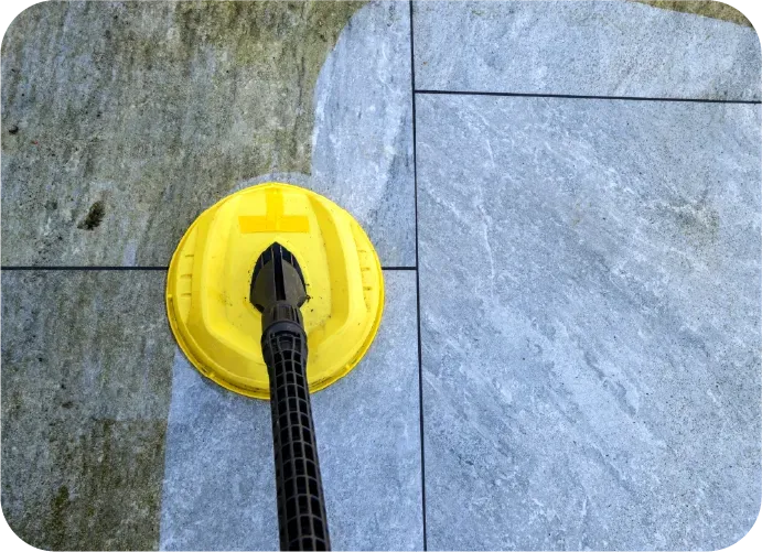 A yellow cleaning tool is being used to clean a tile floor