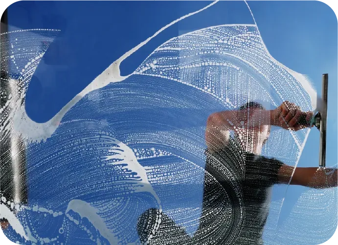 A man is cleaning a window with a squeegee