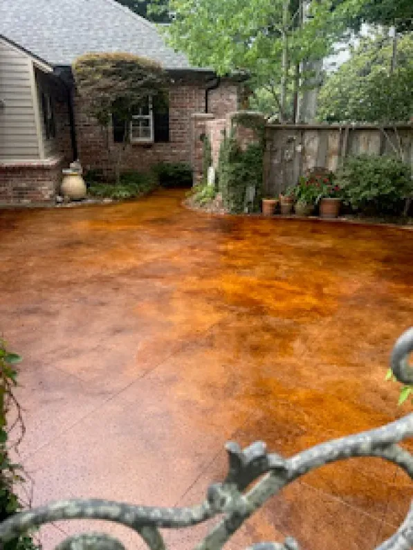 A stained concrete driveway in front of a house.