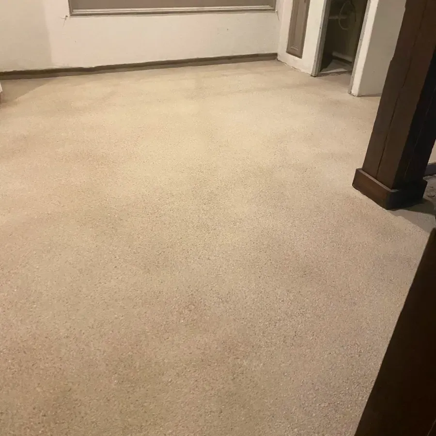 A room with a carpeted floor and a window.