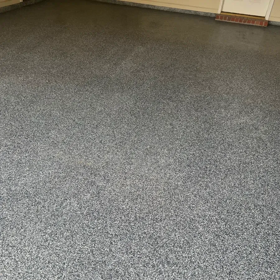 A close up of a gray carpeted floor in a garage.