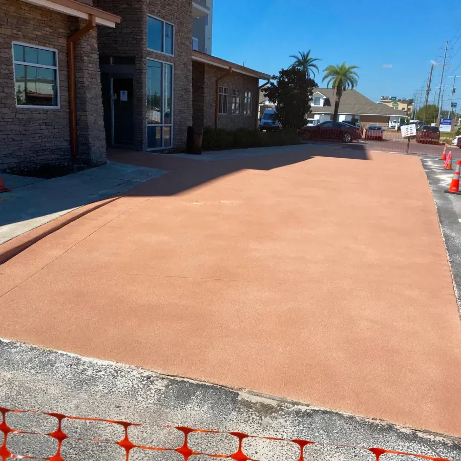 A driveway with a brick building in the background