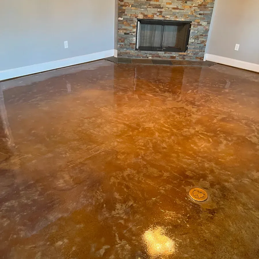 A living room with a stained concrete floor and a fireplace.