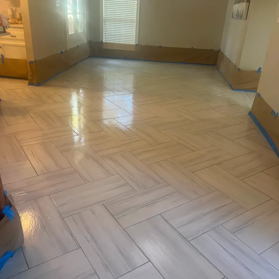 A room with a herringbone tile floor and a window.