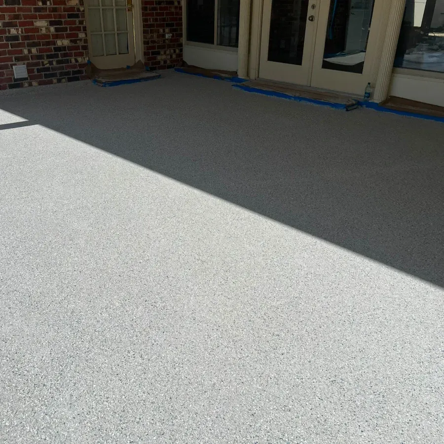 A patio with a brick building in the background