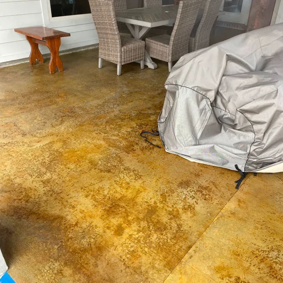 A patio with a table and chairs and a cover on the floor.