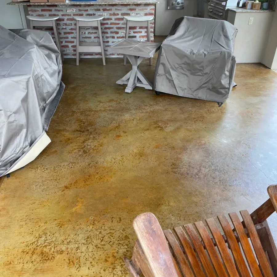 A wooden chair is sitting on a concrete floor next to a brick wall.