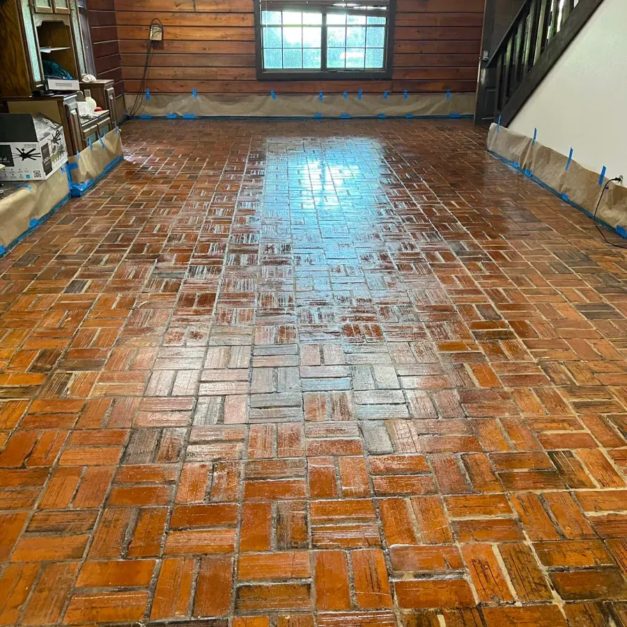 A large room with a brick floor and a staircase.