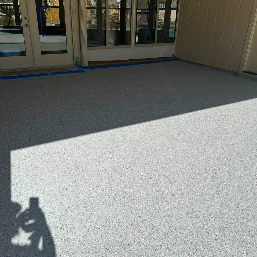 A shadow of a person is cast on the floor of a building.