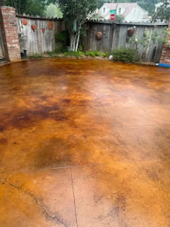A concrete patio with a wooden fence in the background.