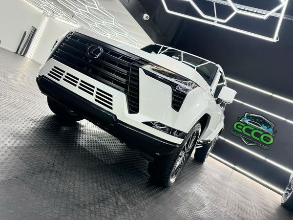 A white truck is parked in a garage next to a sign that says gecco.