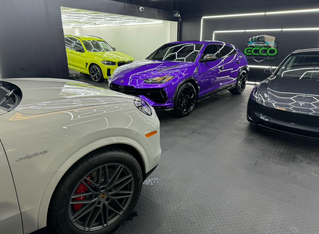 A row of cars are parked in a garage.